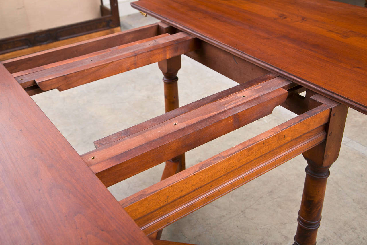 Made in England, this solid cherry table offers the versatility of two 16-inch leaves. On a sturdy base of four turned legs with a strong cross stretcher, it will open from a 51” diameter round to an oblong shape 67” to 83” long. Available in the