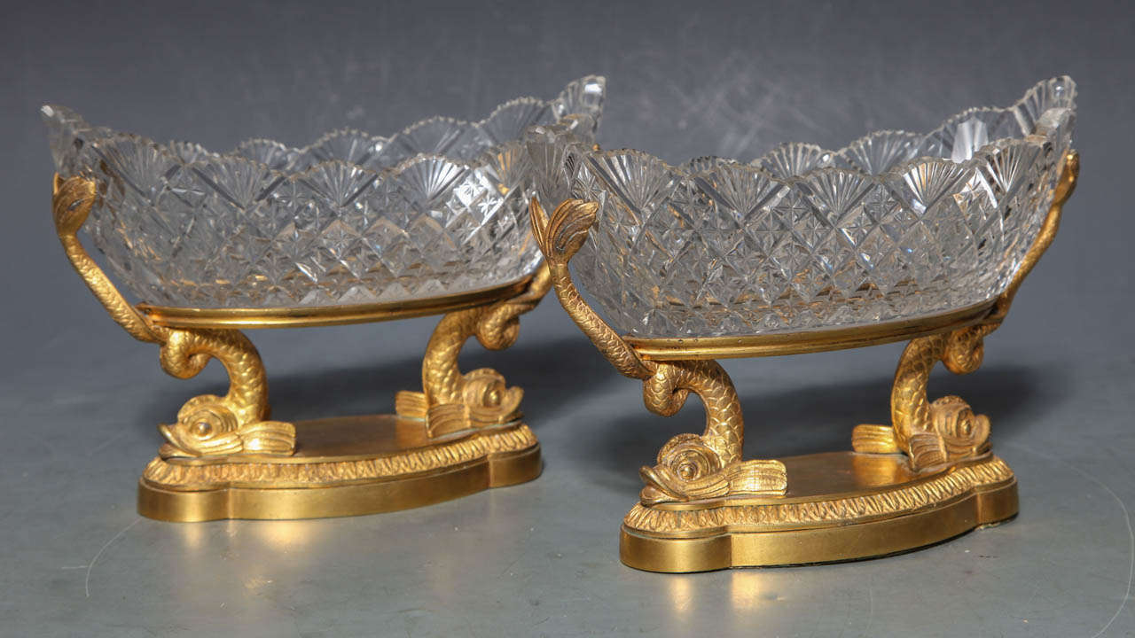 Ein Paar russischer Kristallhalter mit Diamantmuster und vergoldeten Bronzefassungen und Delfinköpfen aus vergoldeter Bronze. Der gewellte Rand der elegant geschliffenen Schalen bildet den perfekten Rahmen für die Meeresbewohner darunter. Gefüllt