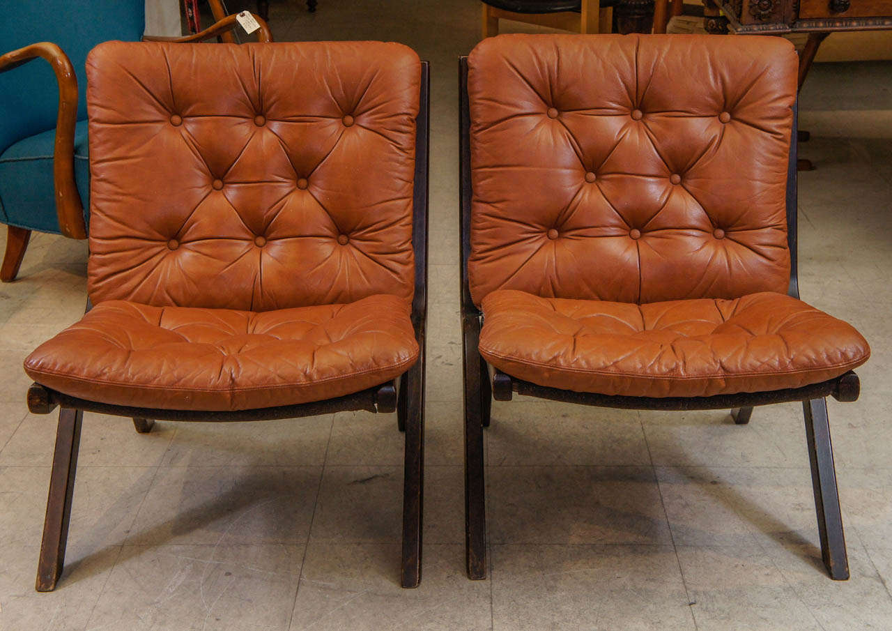 The chairs on inverted V-Legs wtih Tufted Leather Cushions.  Circa 1970s