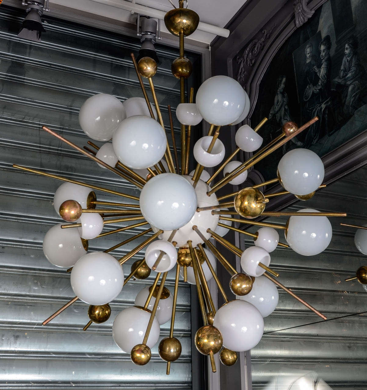 Pair of Spoutnik chandelier from Italy, made in the 1970s, of painted metal, brass and opaline glass. The fixtures are in perfect condition, new electrification, 16 lights per chandelier.

All the arms can be removed from the central piece, for
