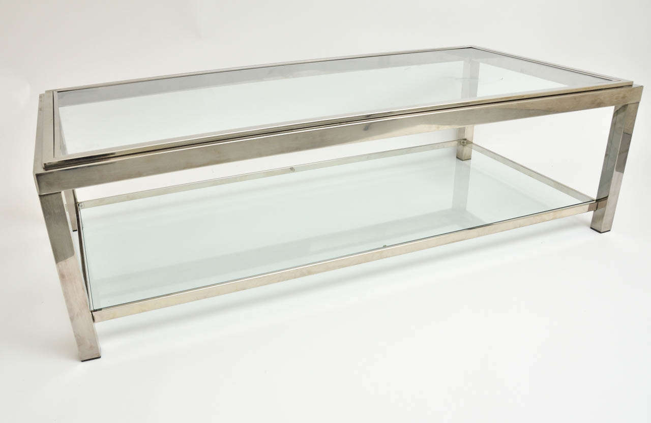 A 1960s chrome and glass coffee table by Guy Lefevre with two tiers, stepped top, and square legs.