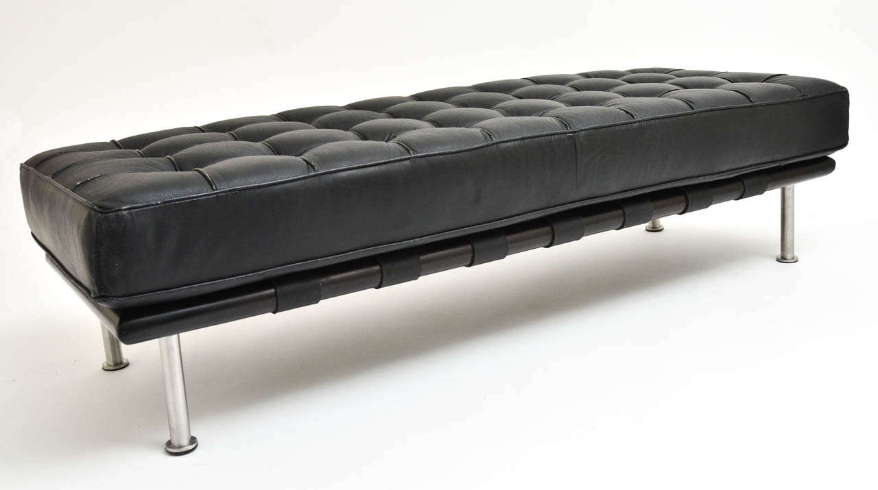 A button tufted black leather bench mounted on chrome legs, original leather.