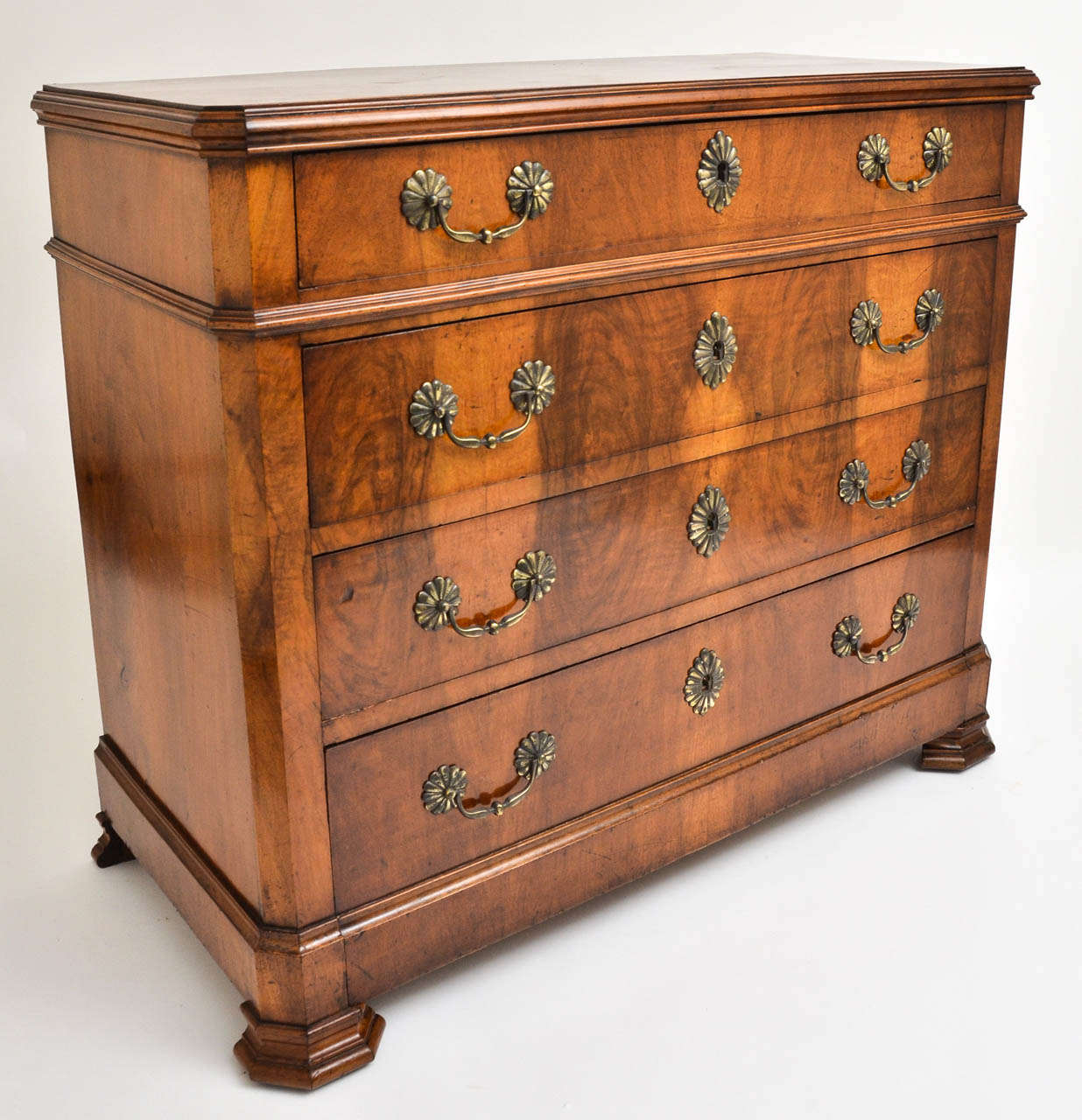 A handsome early 19th Century chest with four drawers, beautiful sunburst brass hardware, centered corners and molded legs