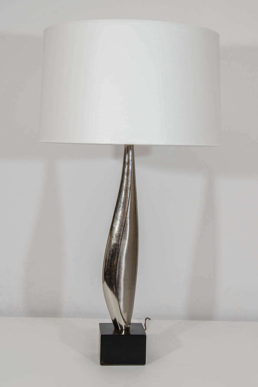 Lovely, gracefully sculpted pair of Laurel table lamps.The lamps have are  chrome in a combination of shiny and contrasting matte finishes. There is a light texture overall. The Laurel Lamp company called this design 