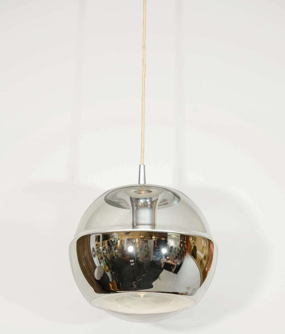 Pair of space age spherical pendant lights by Peill and Putzler. The lights have a molded band on the bottom half that is silvered from the inside. The pendants have the signature sculpted, integrated chrome fitting and socket. Please contact for