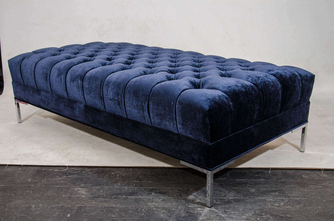 Beautiful bench upholstered in a deeply tufted velvet; shown here in a midnight blue. It is both beautiful and versatile; broad enough to support serving trays, some designers have used it as a coffee table. This piece is designed by and is part of