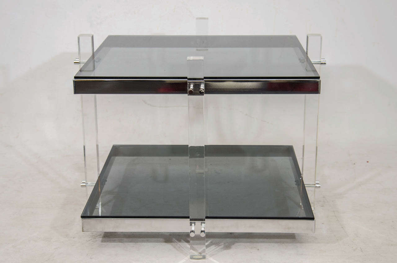 Very beautiful, pair of two tiered side or coffee tables; each with a chrome frame, lucite supports, smoke tinted glass and accented with chrome studs. Please contact for location.