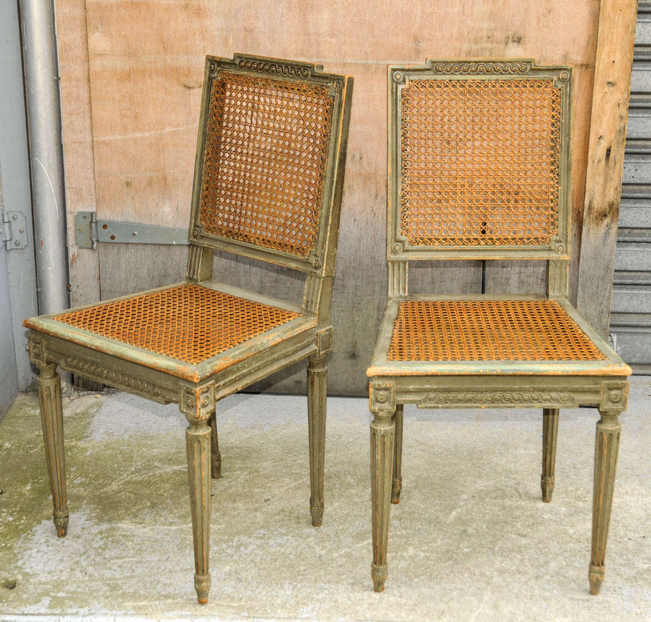 Set of eight 1960's Louis XVI style chairs. Beech tree with old green patina and cane work. Worn patina. Good condition. Normal wear consistent with age and use.