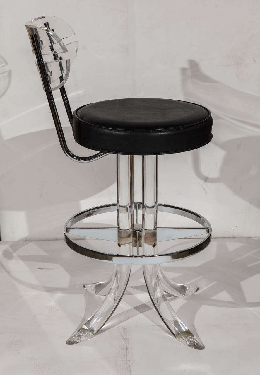 A great pair of mid century Lucite and chrome bar stools with black leather seats that swivel.