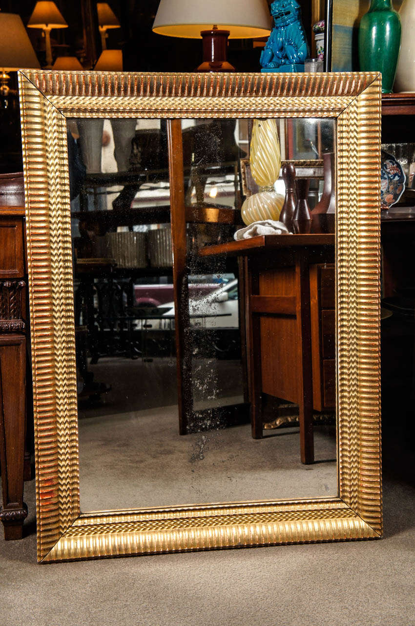 French carved and gilded wood ripple frame with mirror.