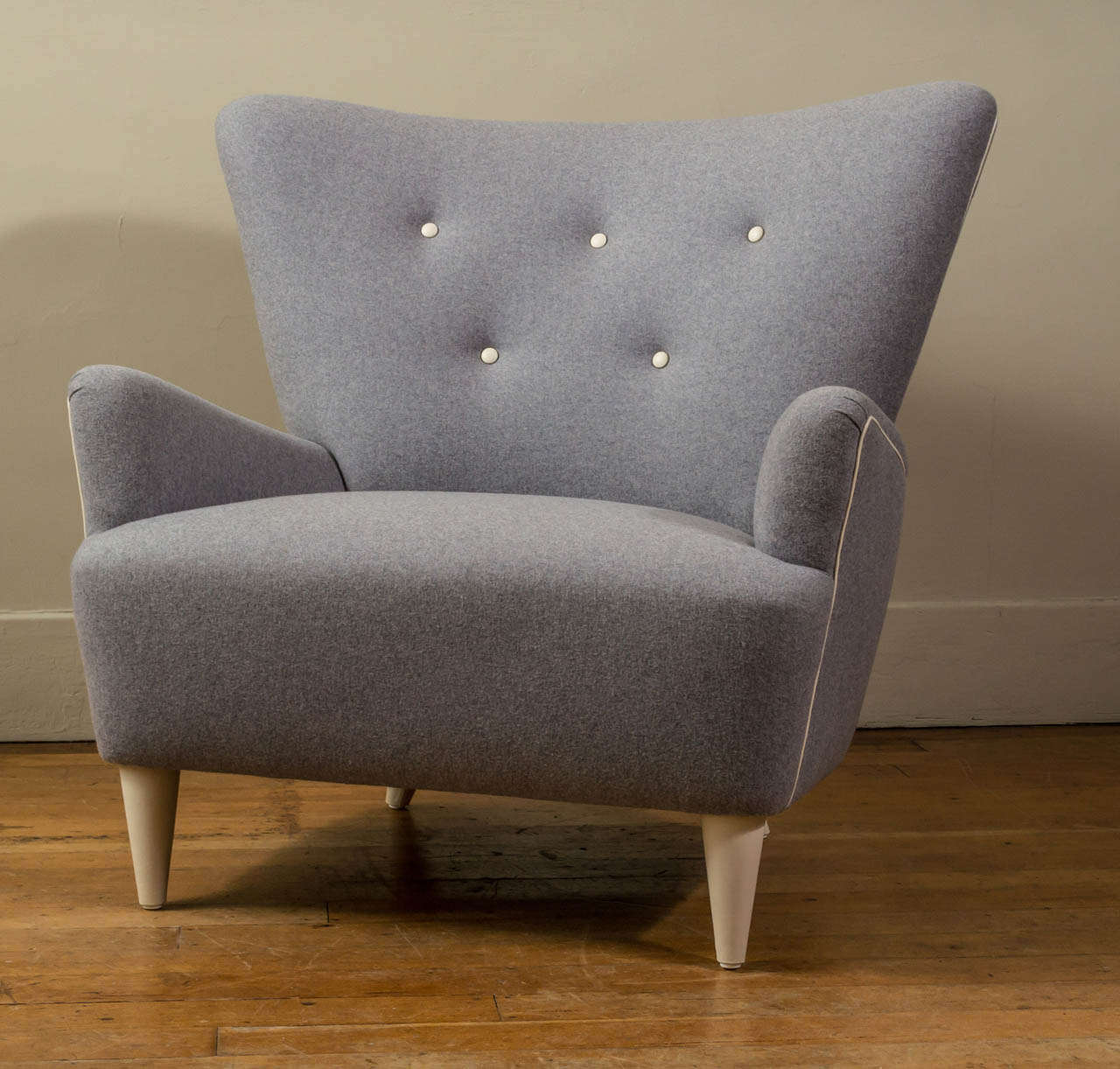 A generous custom Mid-20th Century inspired American armchair in Italian grey wool with bone leather trim and wrapped oak feet.