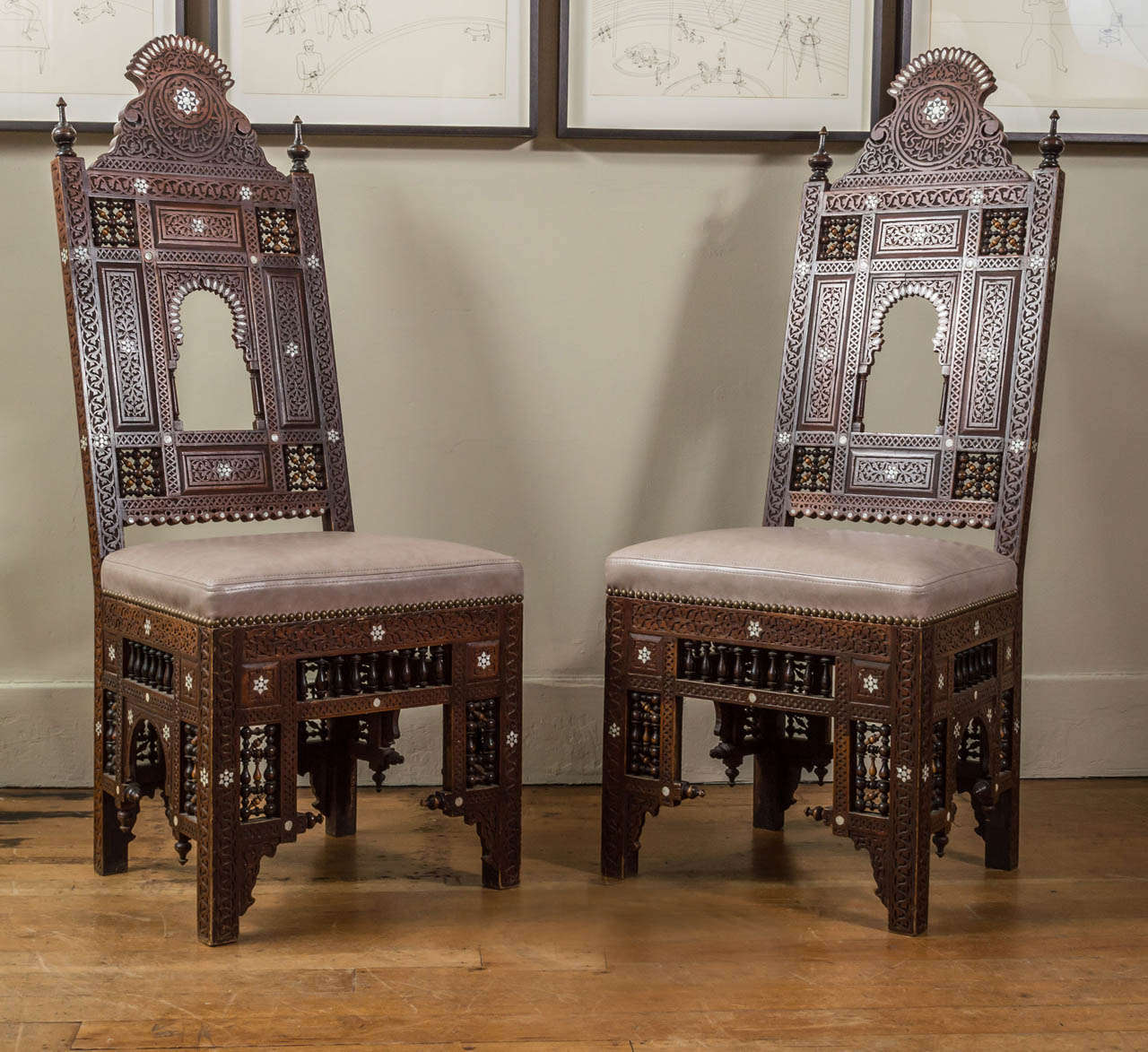 Mother-of-pearl inlaid carved wood side chairs with later leather seats and nailhead trim.