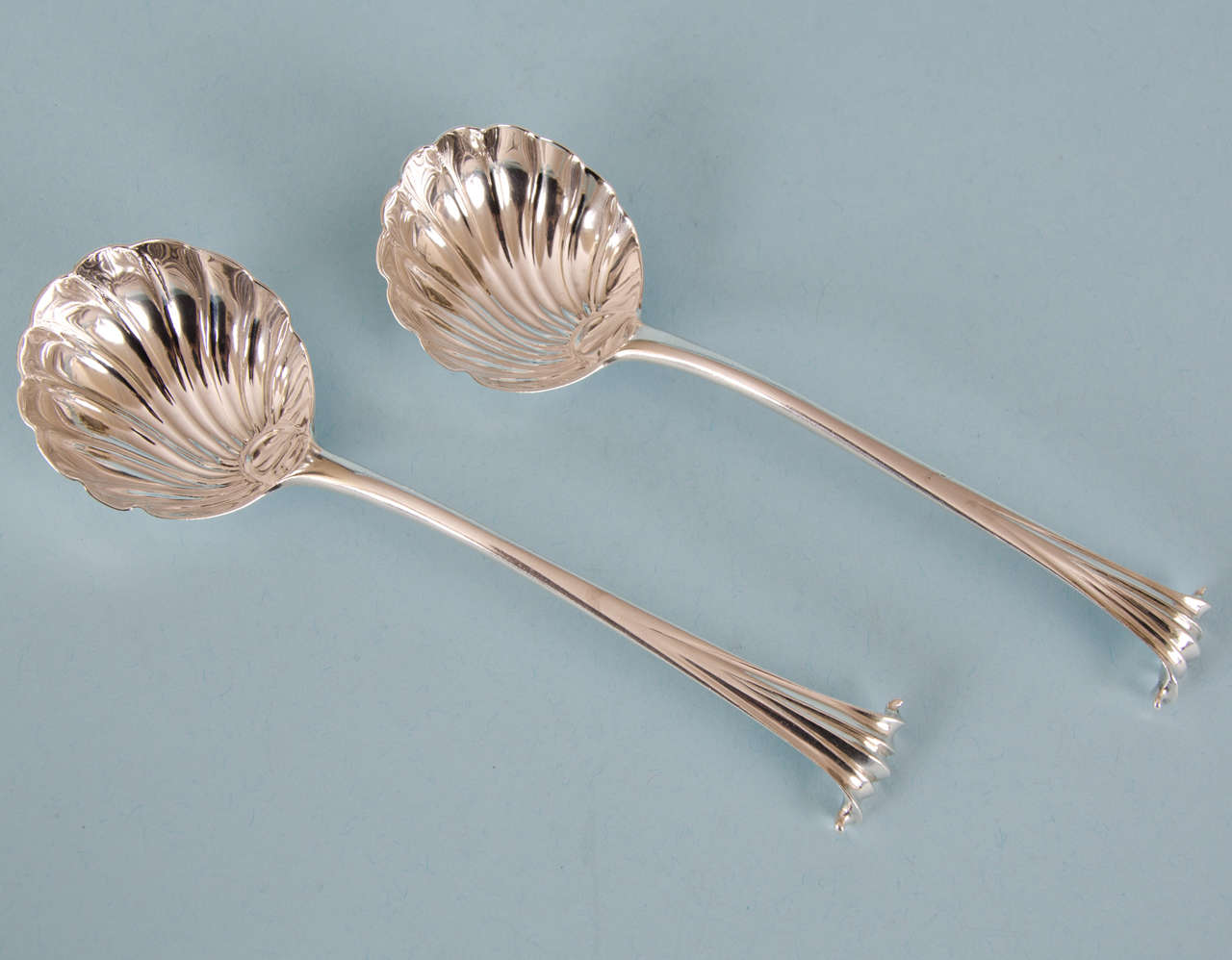 Charming pair of George III sauce ladles in the rare Onslow pattern.
Made by John Lampfert in London, circa 1775. 

Both shell bowls are extremely crisp and the Onslow finials are very well defined. The scarf join is visible on both spoons. A