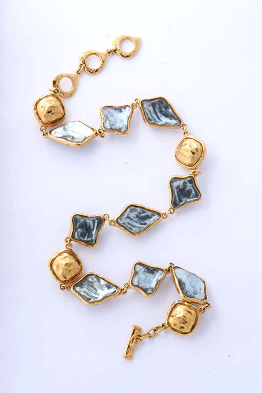 Necklace in gold tone with dusty blue textured stone with toggle closure