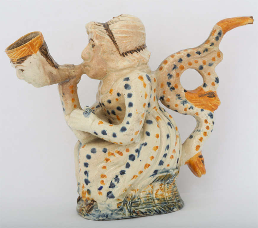 A rare English pearlware pottery Martha Gunn pipe decorated in Pratt colors, two dolphins forming the handle and a man's face in the bowl