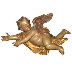 An 18th century French Baroque parcel gilt and polychrome painted carved putto
