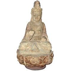 A wooden statue of Buddha sitting on a lotus flower