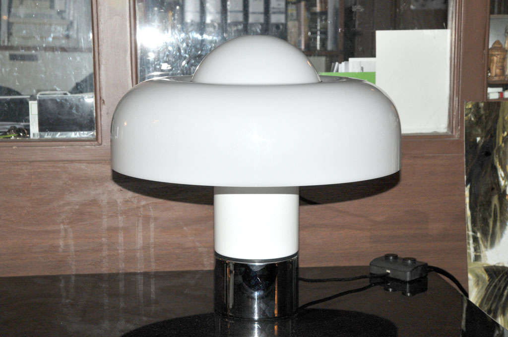 Wonderful table light by the Italian manufacturer Guzzini and designed by Luigi Massoni in 1972. This is the rare all-white version of this table lamp. It has 4 lightsources, the top and sides of the shade can be lit in different light intensities.