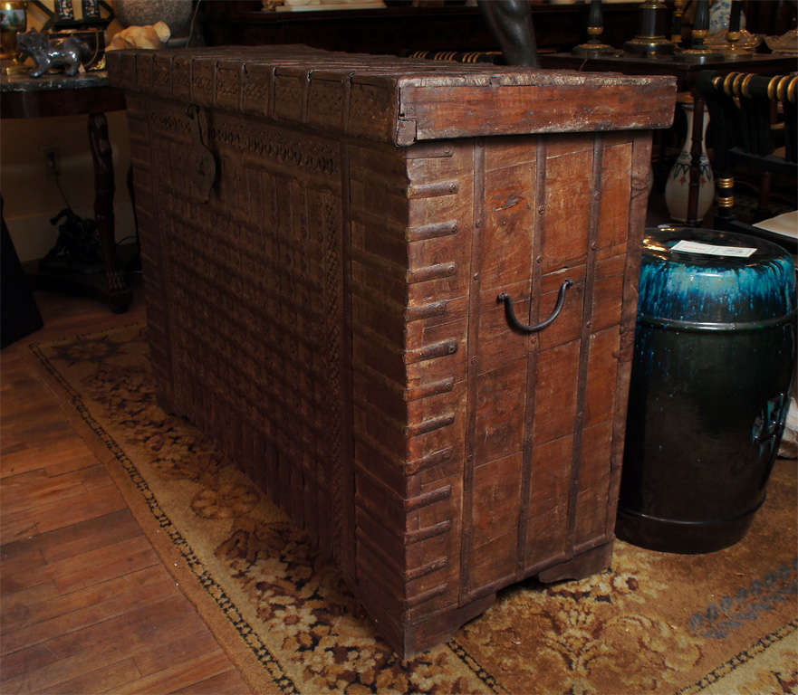 This very large iron bound hard wood chest has many interesting features. The large central latch , as well as the over all decorative pierced iron trim  and large iron banding give the piece a distinctive nature while the old dry wood makes the it