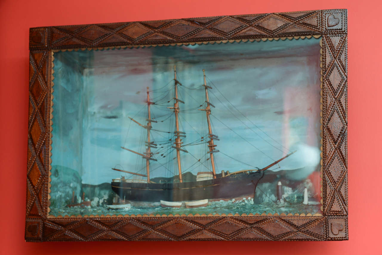 Superb example of an all original late Victorian era tramp art diorama in which you can see a three dimensional miniature of a nautical nature. Large three masted clipper ship a sail with tugboat and lighthouses. There is a deep blue green