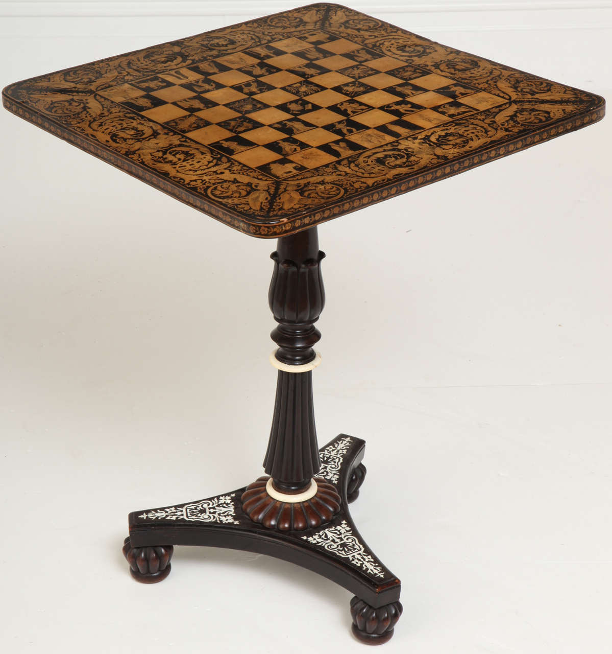 A good Anglo-Indian tilt-top penwork games table with finely decorated checkerboard top and ivory-inlaid ebony pedestal base in the manner of George Merrifield.