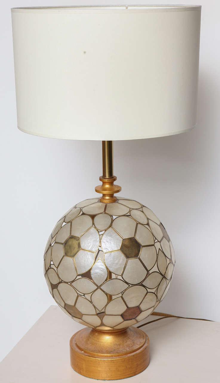 Dramatic table lamp made of Capiz-shell flowers forming a spherical shape, complemented by a gold wood base and neck.  USA, circa 1950.