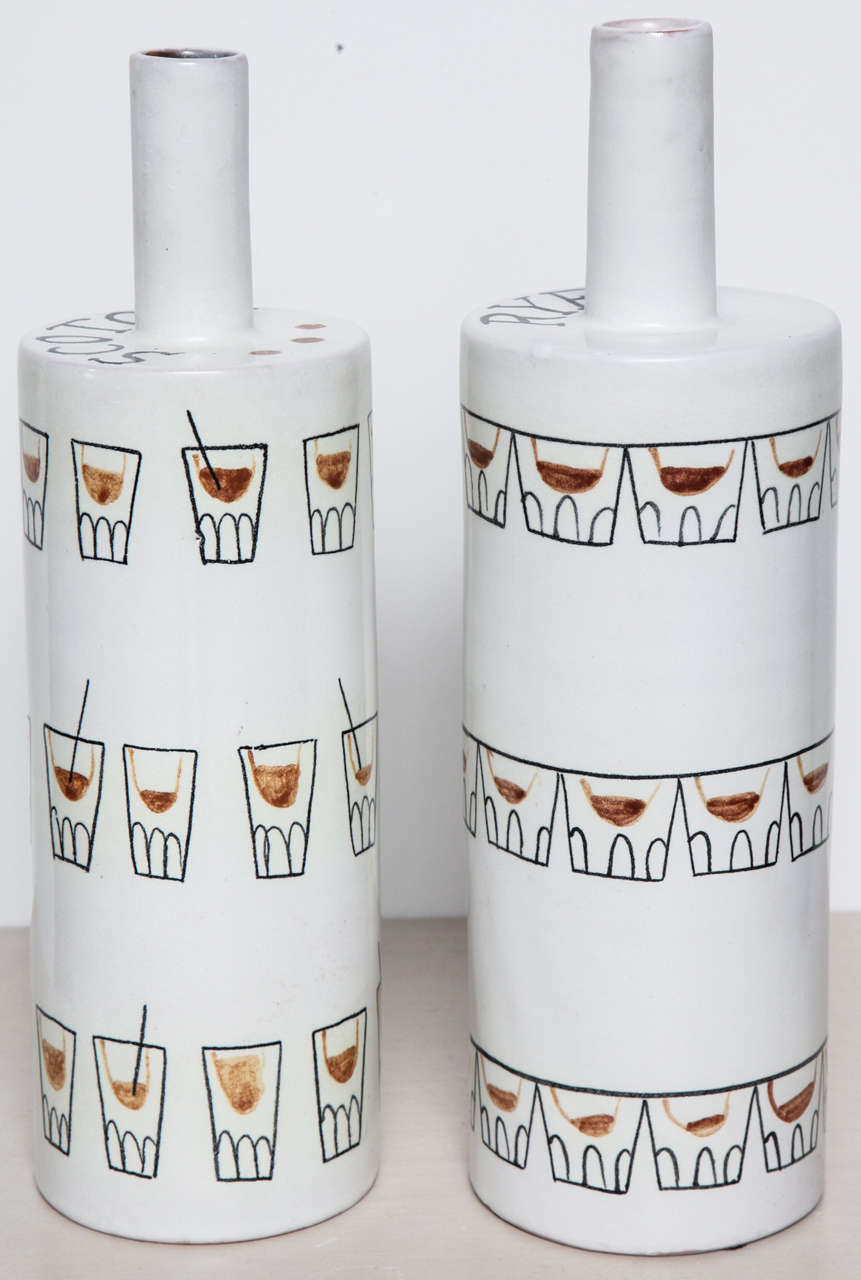 Pair of whimsical ceramic bottle vases by Raymor.  Italy, circa 1960.  Signed.  One bottle features double old fashioned drinking glasses; the second bottle shows highball glasses.  May be electrified and made into lamps for an additional fee.