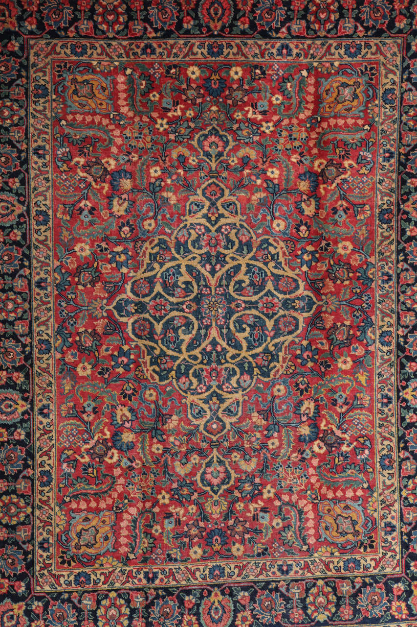 This Persian Kermanshah carpet from the village of Songhor circa 1910 consists of a hand-knotted handspun wool pile and natural vegetable dyes. The medallion design features exceptional detail and Classic coloration of reds, blues and golds. Carpets