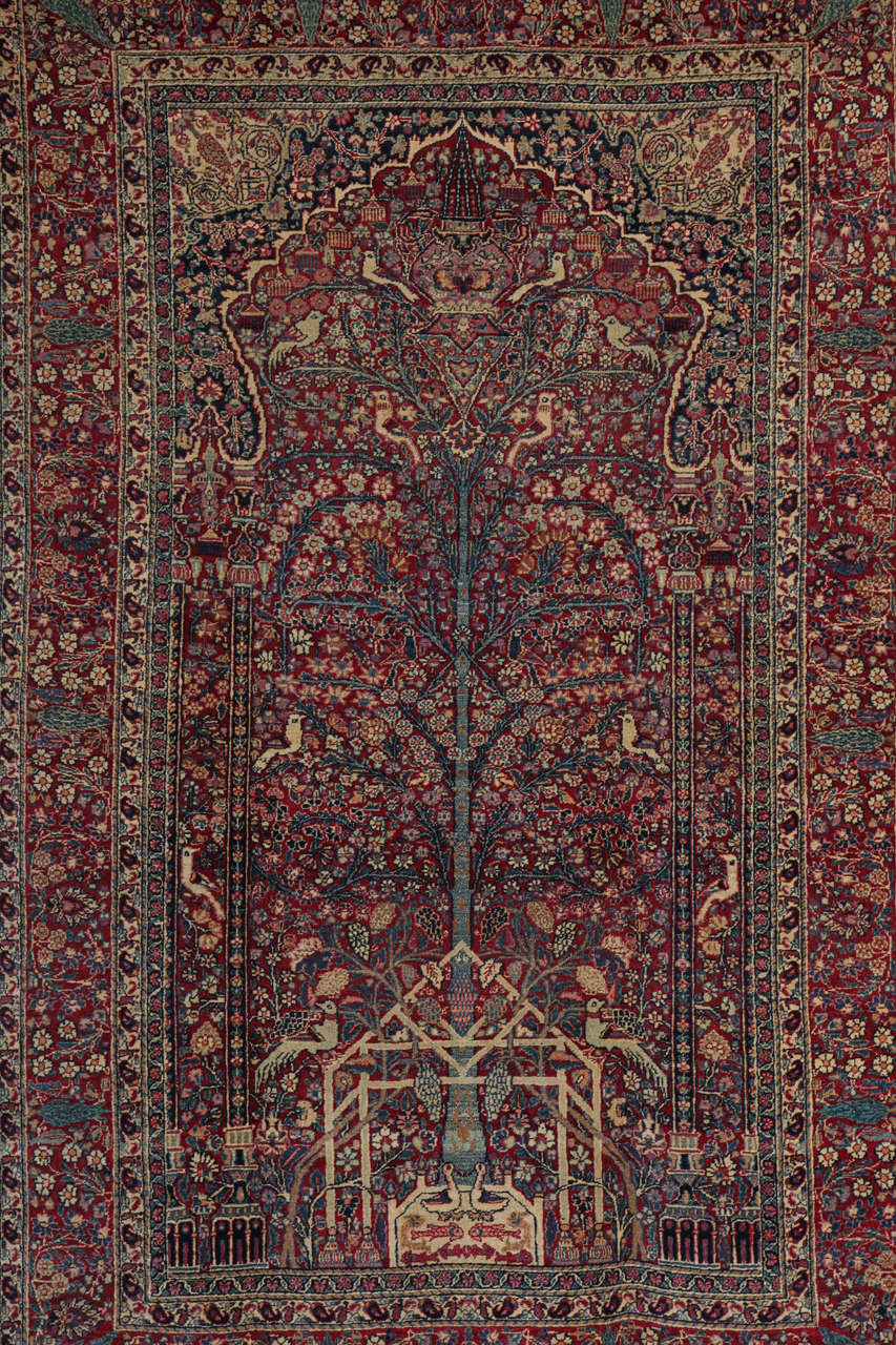This Persian Tehran carpet circa 1900 features a Tree of Life design and consists of a cotton warp and thread, a hand-knotted pile of handspun wool, and natural vegetable dyes. It is an exceptionally fine and detailed piece, in which the artist has