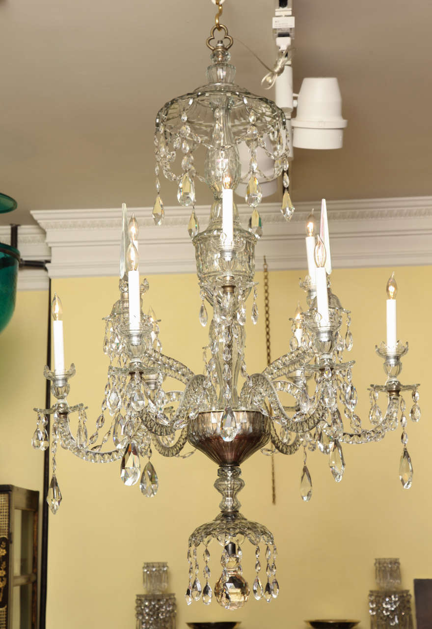 Fine Adam Style Nine Light Cut Crystal Chandelier,  having a shaped and faceted pendant canopy above a central shaped diamond cut classical urn, with  six serpentine upturned faceted arms having three lights and three spires, above six serpentine