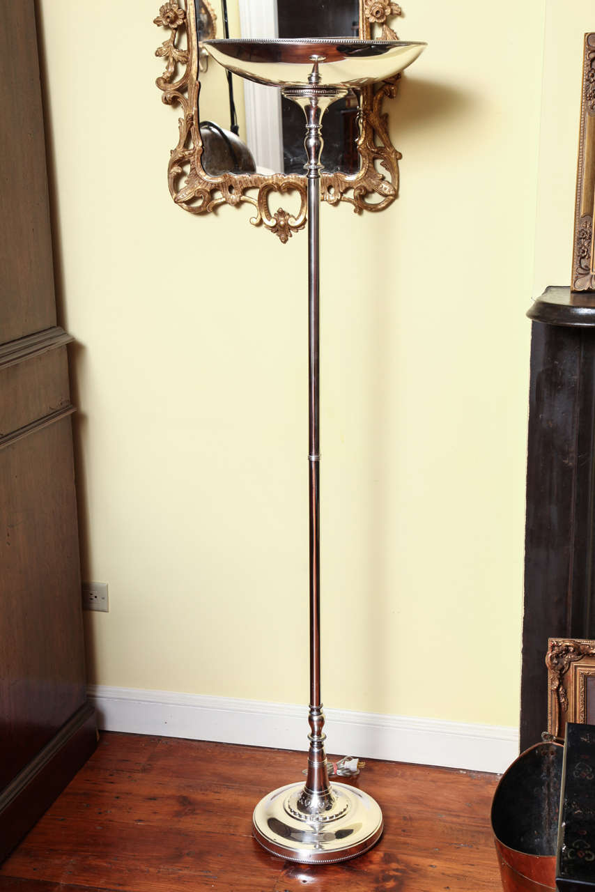 An Art Deco period silver plated torchere/floor lamp, the wide, round shallow bowl having a finely beaded edge, with 4 porcelain sockets inside, over a cylindrical support punctuated by baluster and ring decoration, terminating in a spreading round