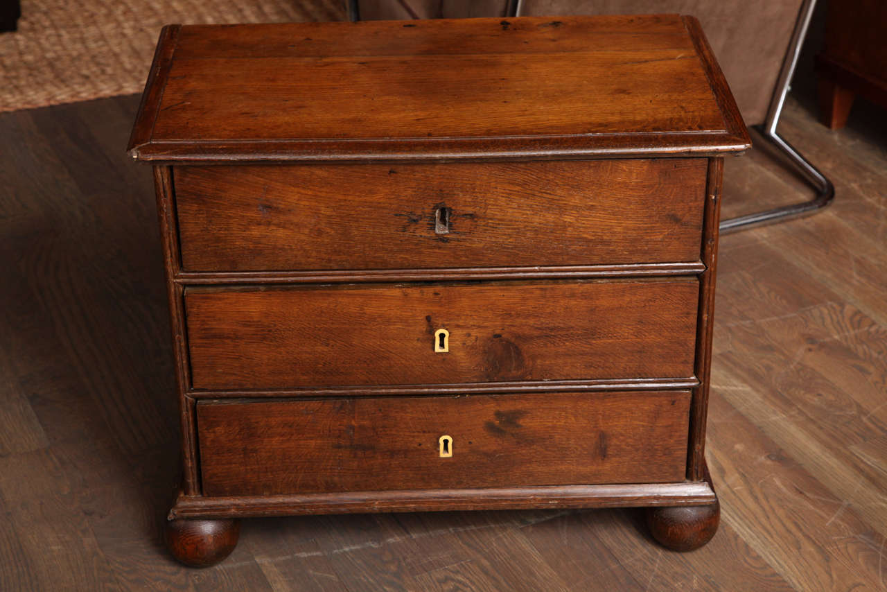 A diminutive chest of drawers of mahogany with wonderful ball feet and two Ivory keyholes. A rare find.