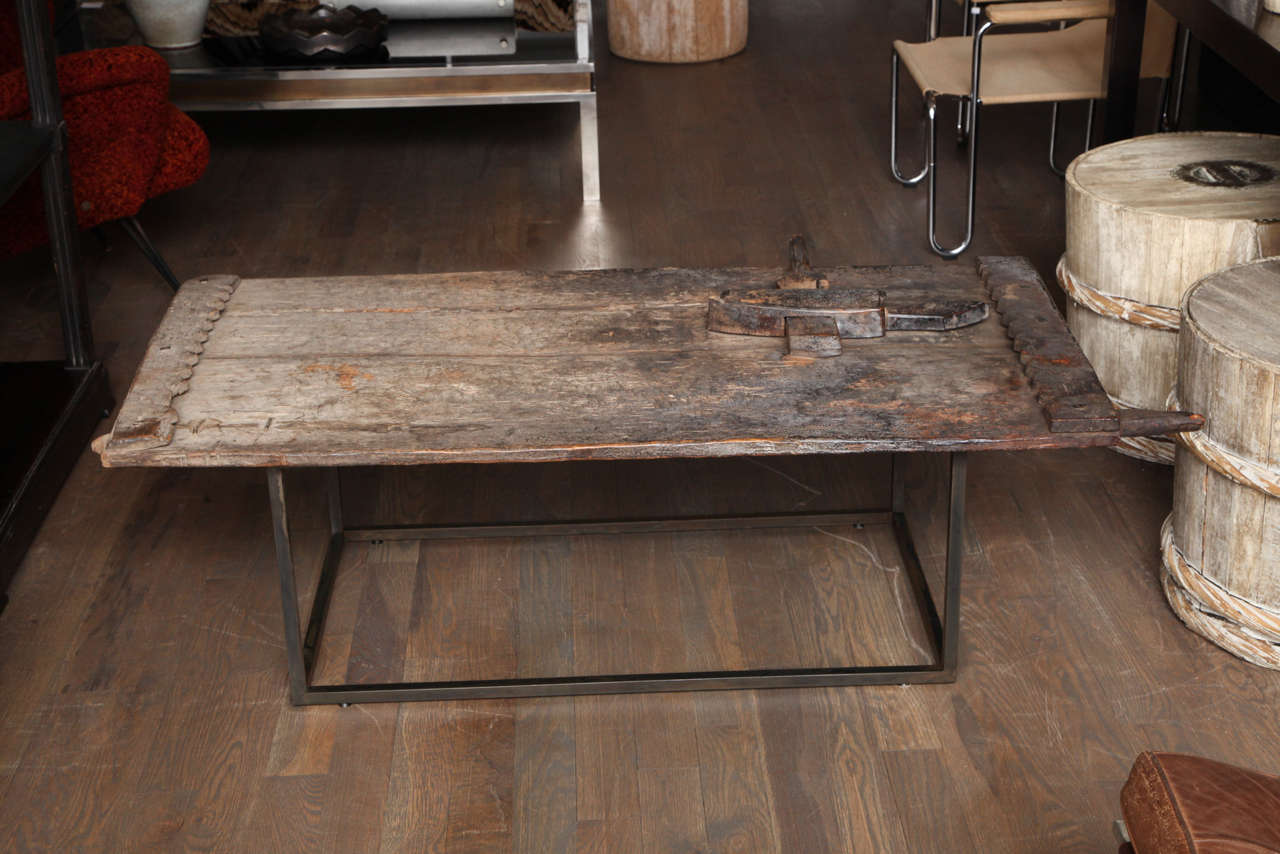 A primitive African grain door from Dogon used as a coffee table. The wood has a wonderful rich patina and the latch is attached which acts as an object atop the table.
