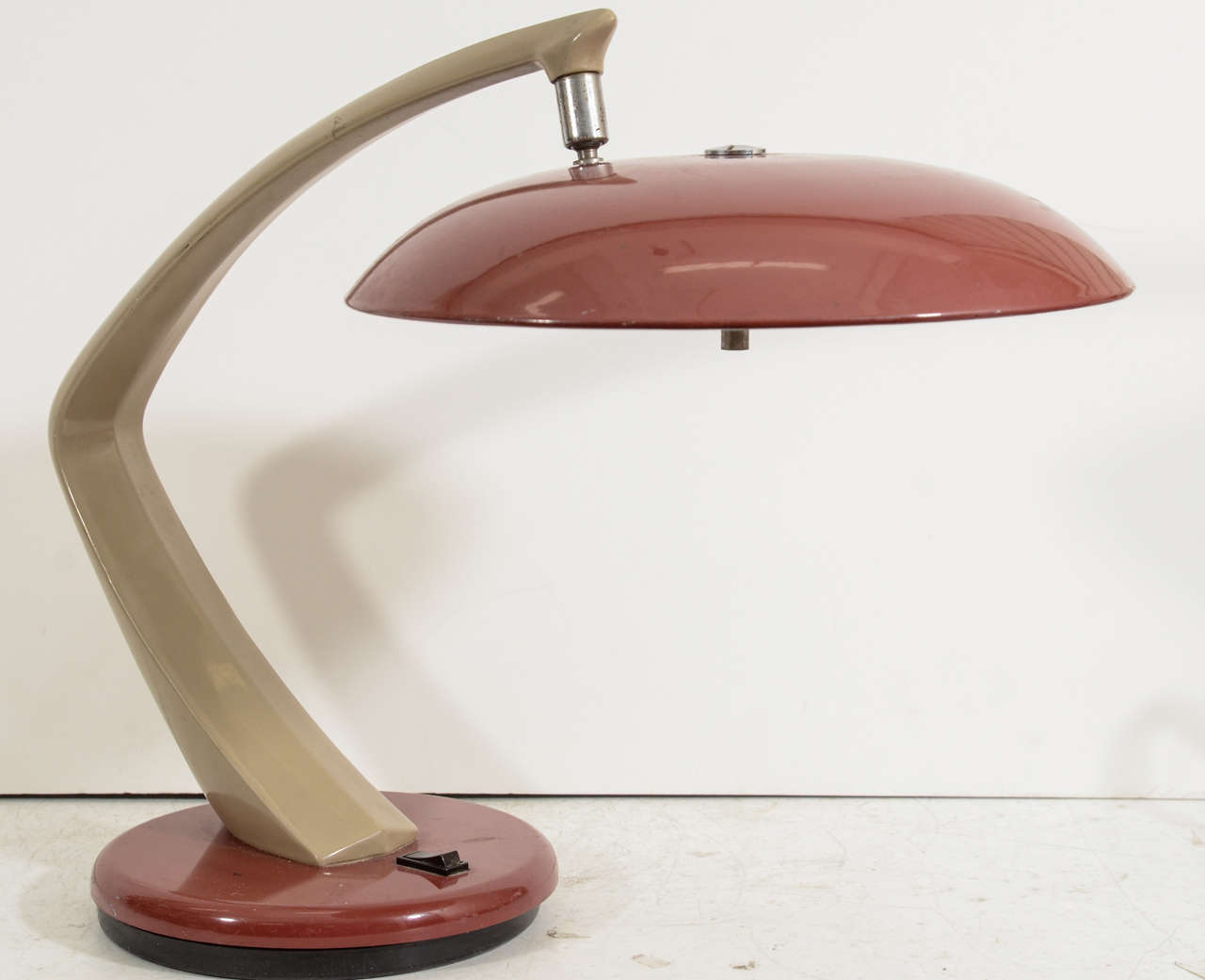 A vintage desk lamp by Fase, produced circa 1970s, with red enameled shade and beige arm. The piece is in good vintage condition, with age appropriate wear, including minor scratches and scuffs; the glass diffuser is missing.