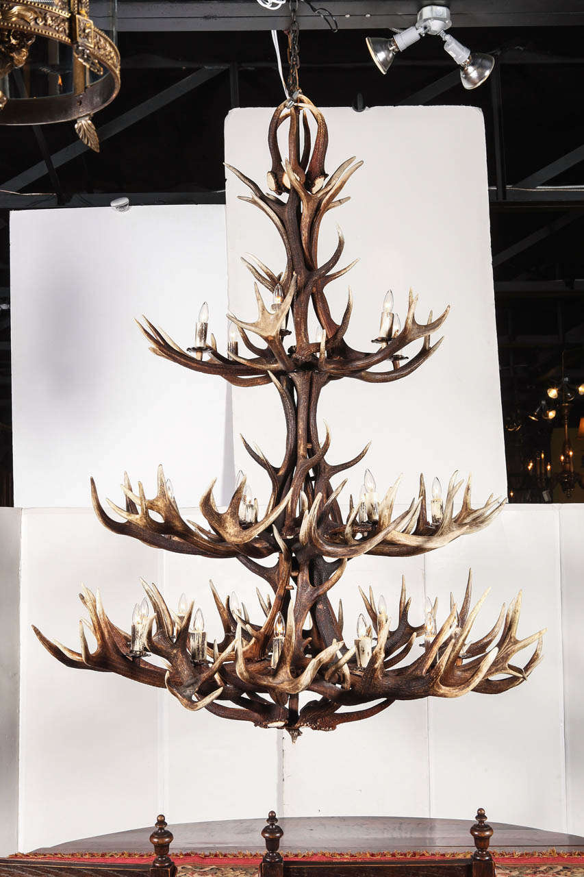 This monumental antler chandelier is comprised of 60 natural antlers, primarily elk. This 24 light fixture is divided up into 3 tiers all wired and connected. A grand piece for any mountain lodge, hunting ranch or a large cathedral ceiling in a