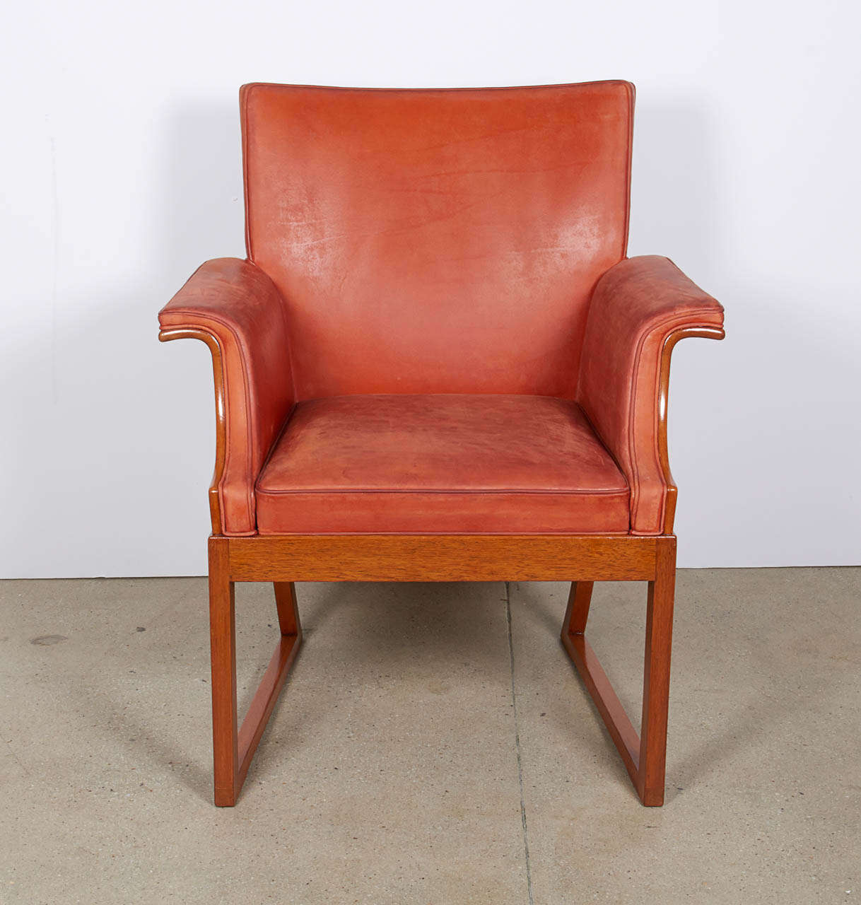 An elegantly proportioned armchair, the exterior entirely in figured Cuban mahogany, the interior in soft orange leather. Attributed to Frits Henningsen (Danish, 1902-1971). Very fine original condition throughout, an age crack to the back surface