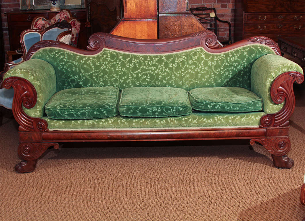 American Mahogany Neoclassical Empire Sofa

This is a large three cushion sofa from the American Empire period.  It is all original including the lion's paw feet.

It features beautiful scroll work and carving.

The fabric is old and worn and