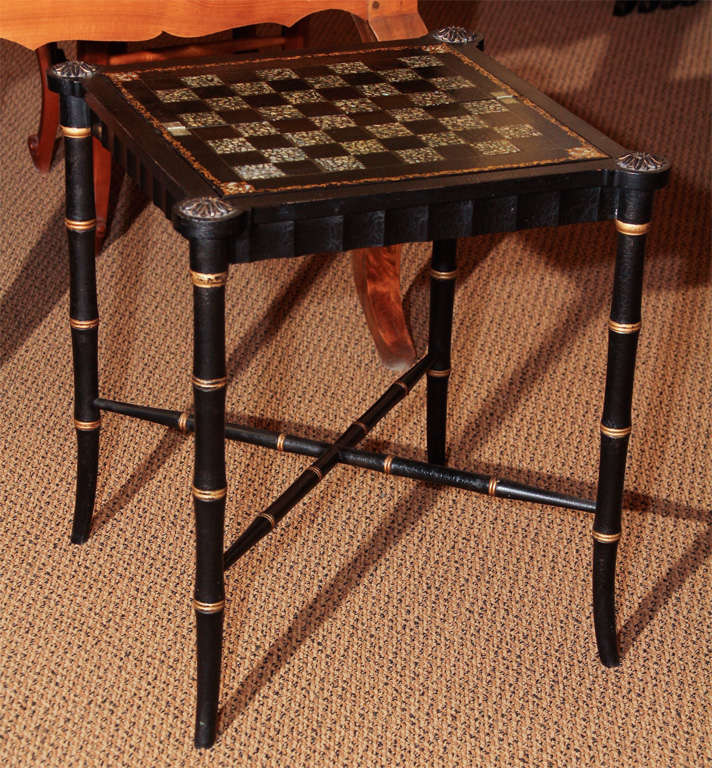 English Paper Mache Game Table on Stand

This is a folding antique game board that we put on a custom made stand to create a table.

The game board is chess a pattern with gilt and abalone inlay. 

The base is faux bamboo with gilt accents.