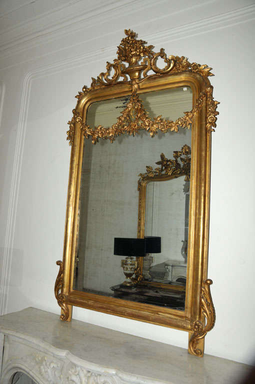 A large 19th century French giltwood wall mirror in Neoclassical style, with overlapping guirlandes