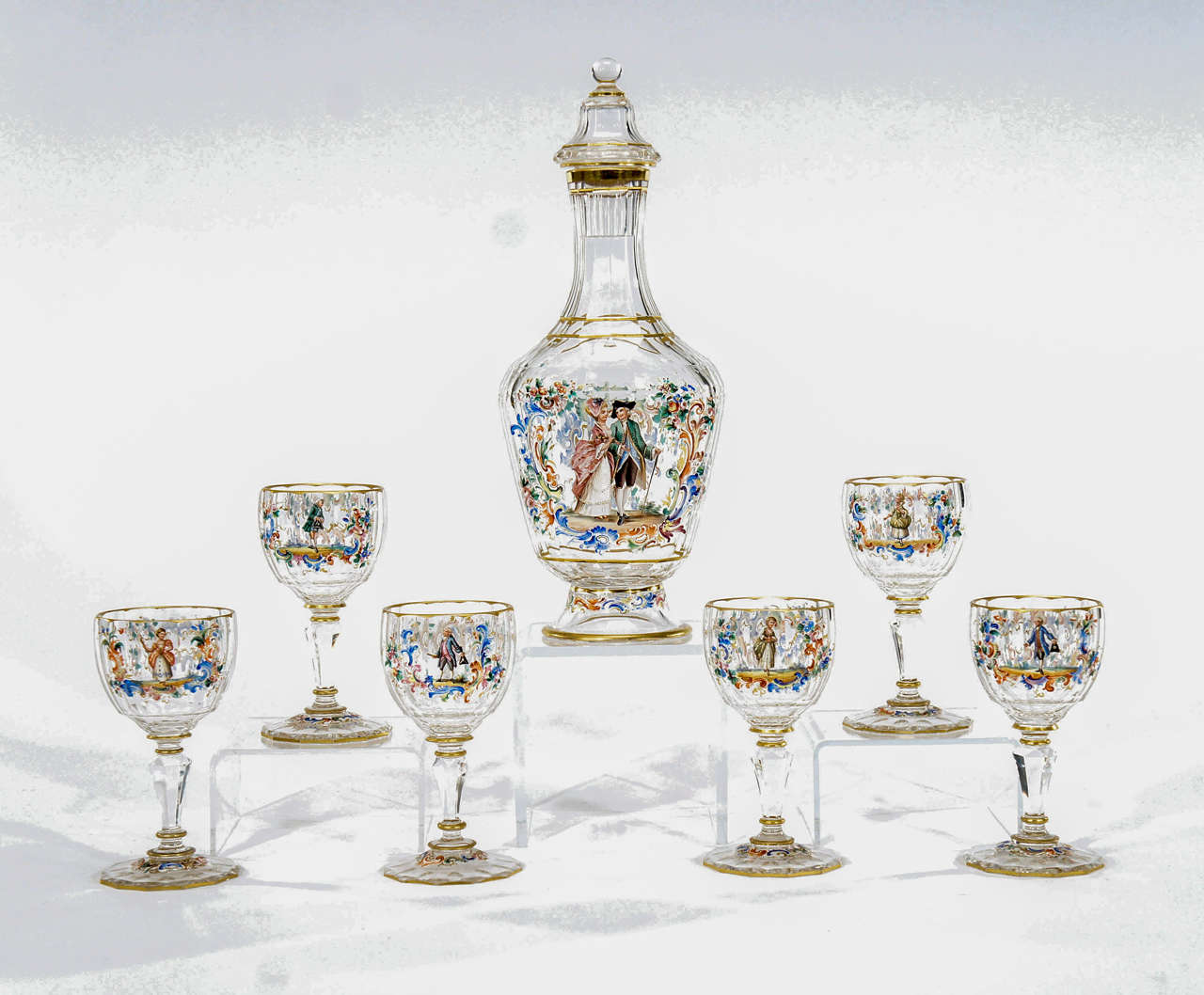 A beautiful and rare set of signed Lobmeyr includes a tall decanter and 6 matching dessert wine goblets. Each piece is hand blown, facet and panel cut and the foot is hexagonal and gilded. Each one is painted in bright polychrome enamels with
