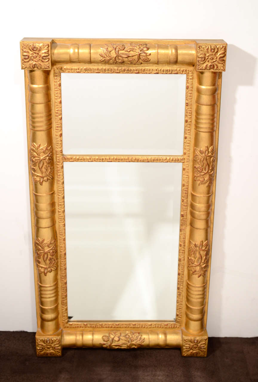 Traditional gilded wood mirror with hand laid antique gold leaf finish, sculpted moldings design and wood blocked corners with hand-carved details. The mirror also features hand beveled insets. Great scale for an entry way, hallway or a powder room.