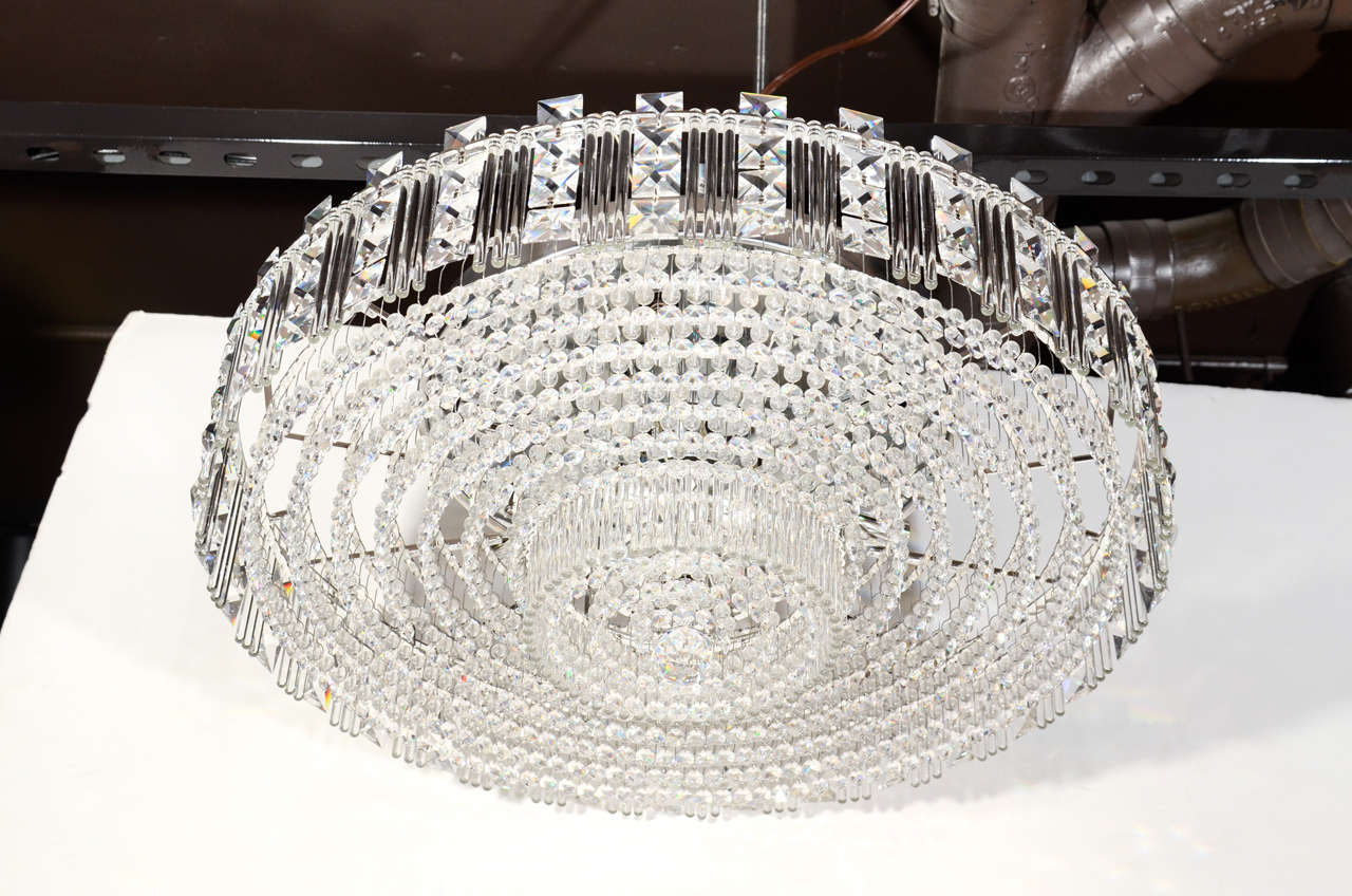 Spectacular Mid-Century large Hollywood Regency cut crystal chandelier. Comprised of 12 circular rows of alternating diamond shaped faceted crystals, as well as cut crystal pendants, and multiple rows of glass rods. The chandelier has a flush mount