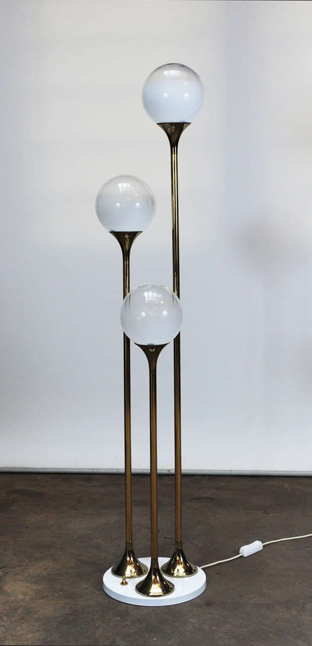 Wonderful floor light by Italian designer Targetti Sankey, with 3 milk glass spheres on 3 brass stems on a white lacquered metal base. The switch is multi-functional to light one, two or all 3 lights. 
there are 2 identical available, price is per