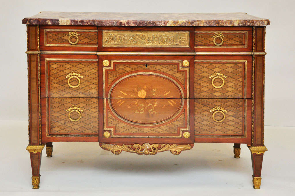 French Louis XVI style chest of drawers or commode after a model by Jean-Henri Riesener. Rectangular rouge marble top surface with bold veining, smaller drawer in frieze with centered 22K gold mercury bronze middle drawer frieze 