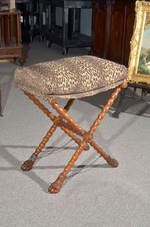 English folding stool with turned legs with hairy paw feet and original chain to keep it from opening too wide. It has dramatic recent faux leopard print cushion. Taller than most stools-it would be great for a dressing table.