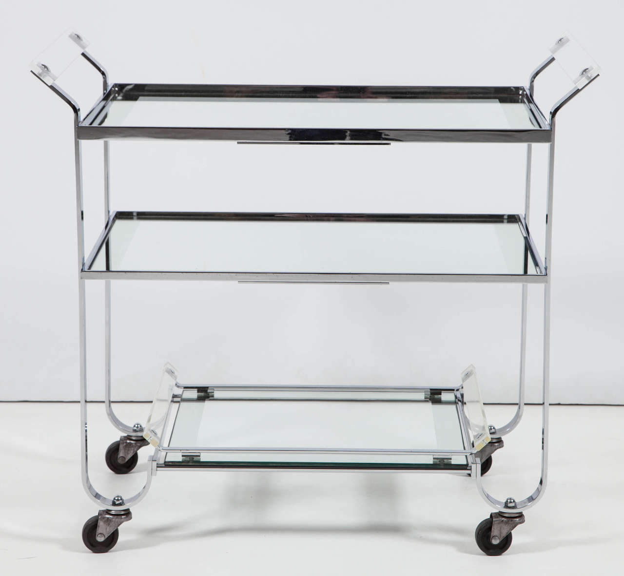 Decorative chrome bar cart, C 1950, Italy. 3 shelves, the bottom is a tray. Lucite handles. The bar cart is 24