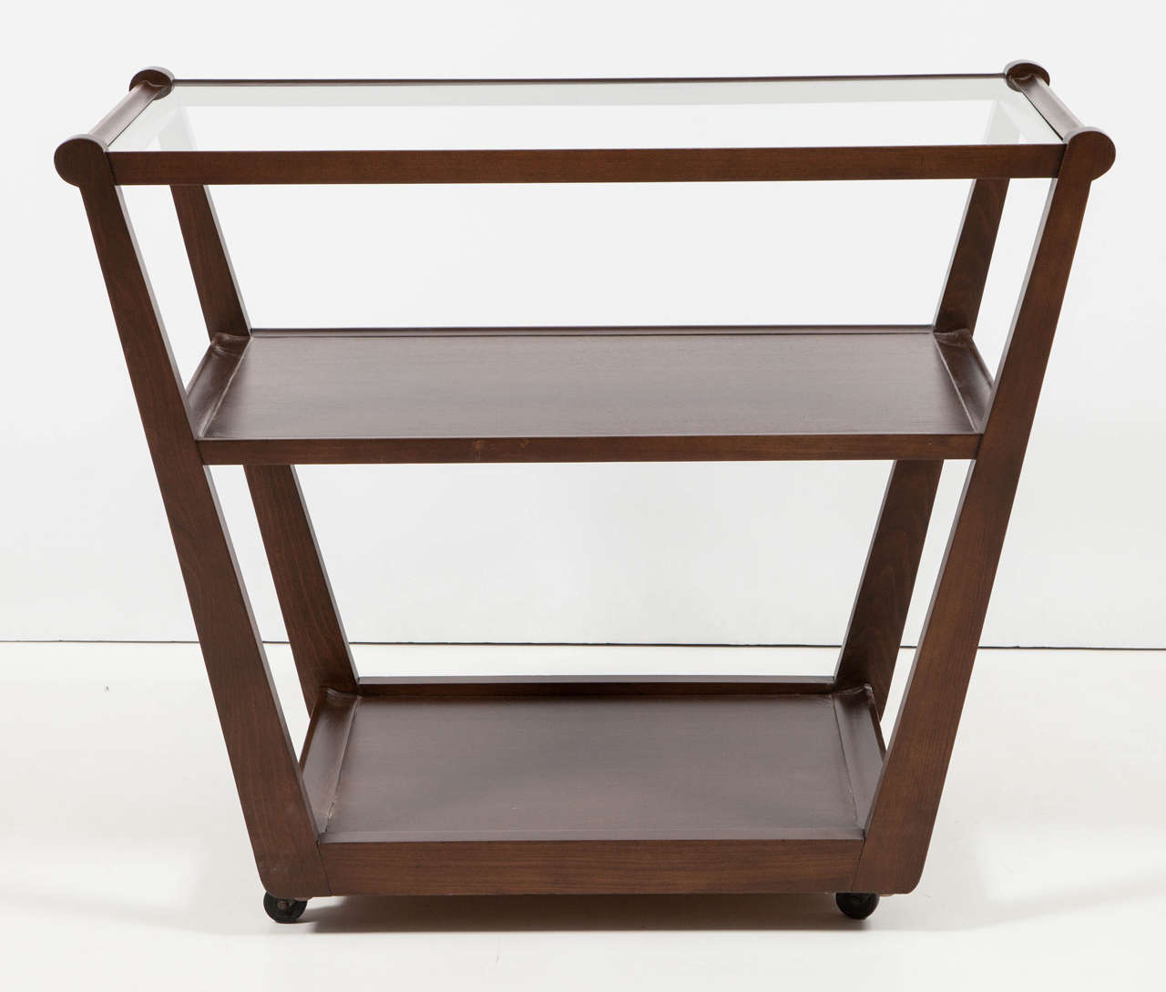 Sculptured trapezoidal three-tier serving cart in medium walnut finish by Edward Wormley for Drexel. Newly refinished to original specification.