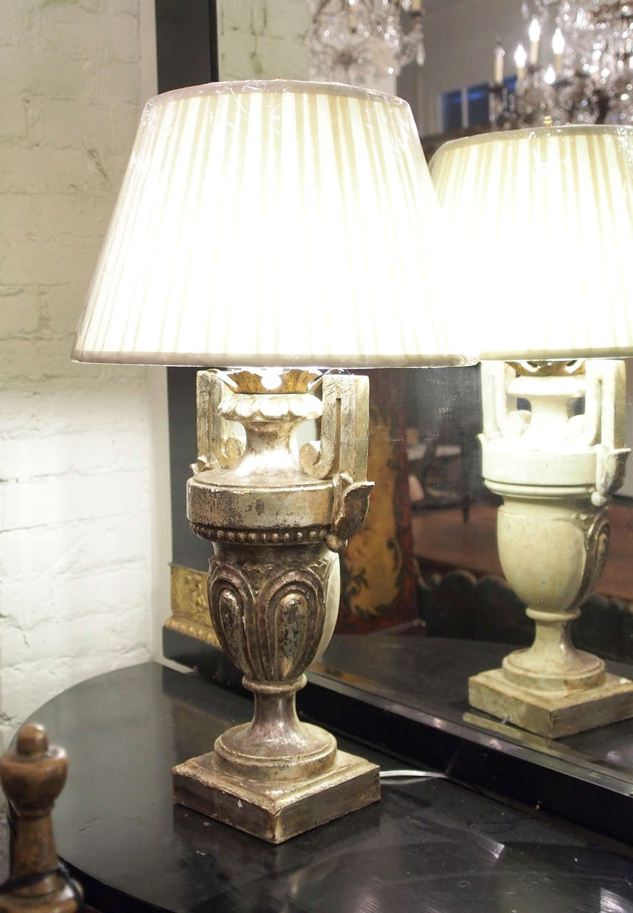 A pair of Italian late 19th century silver gilt urns in the Louis XVI style now drilled and mounted as table lamps.