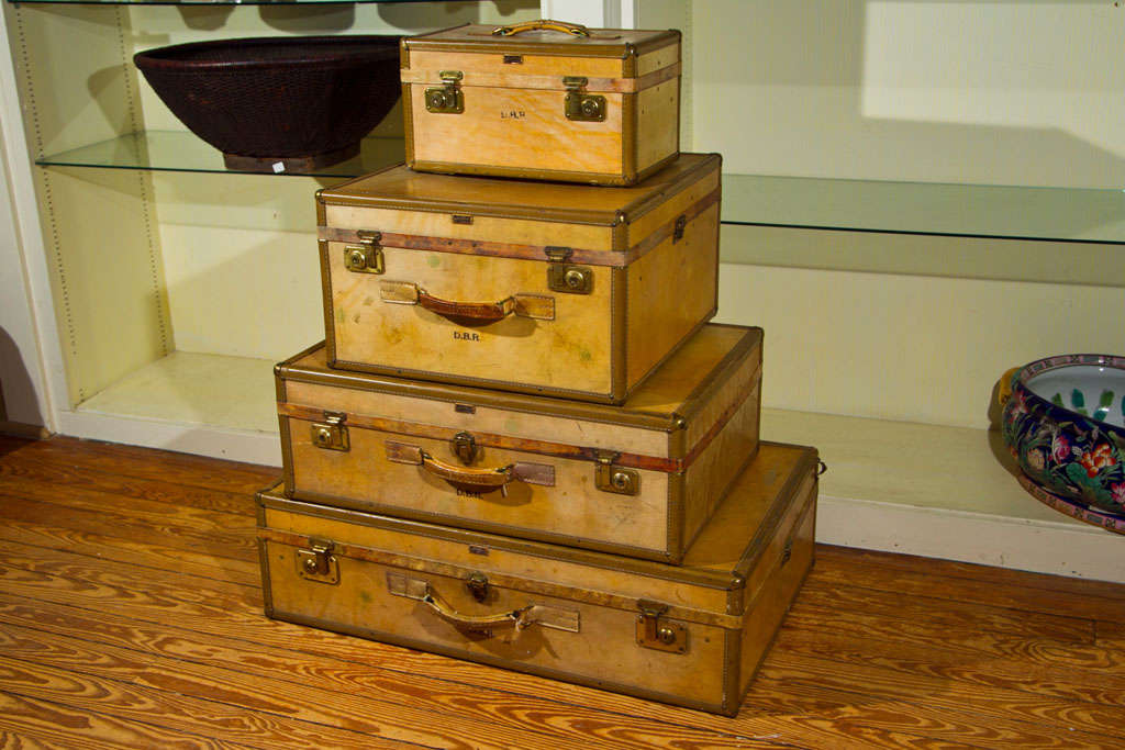 A SET OF  4 MATCHING PIECES OF HAND LUGGAGE BY HARTMAN, COVERED IN PARCHMENT (PROBABLY  GOAT OR SHEEP SKIN) WITH LEATHER HANDLES AND BRASS CORNERS. EACH INITIALED DBR. (HARTMAN MAKES LUGGAGE FOR T.ANTHONY). LARGEST IS 32 1/2  WIDE , SMALLEST IS  15