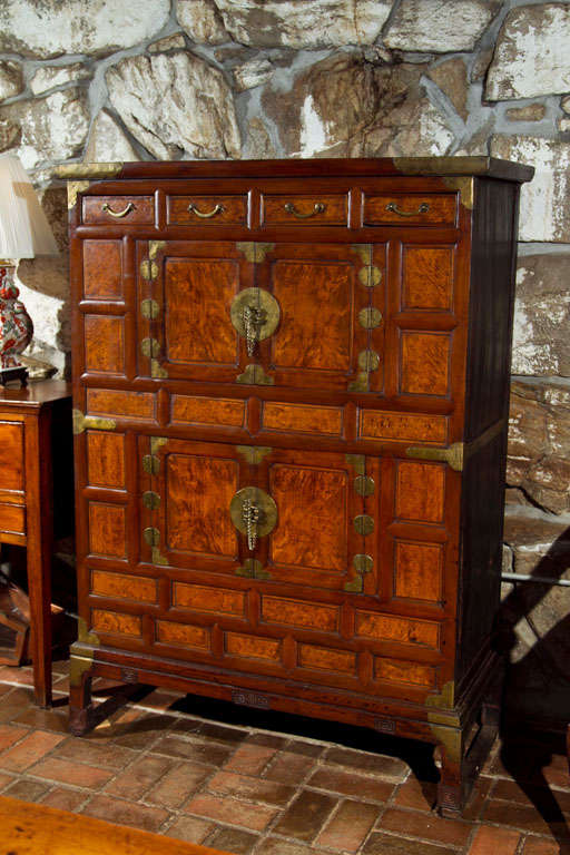 This chest is constructed primarily of pine, but the recessed front panels appear to be walnut burl. A beautiful, rich patina is what draws the eye to this chest, the warm hue of the brass trim and hardware only enhances this effect.